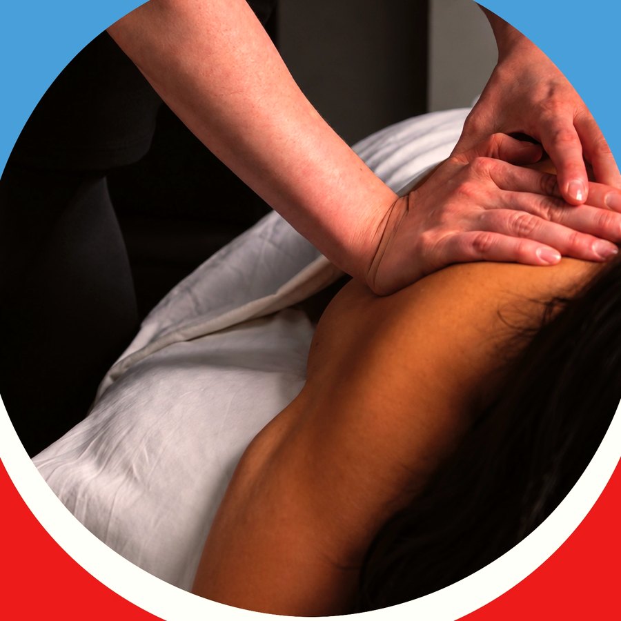A practitioner's hands working along a client's thigh on the treatment table
