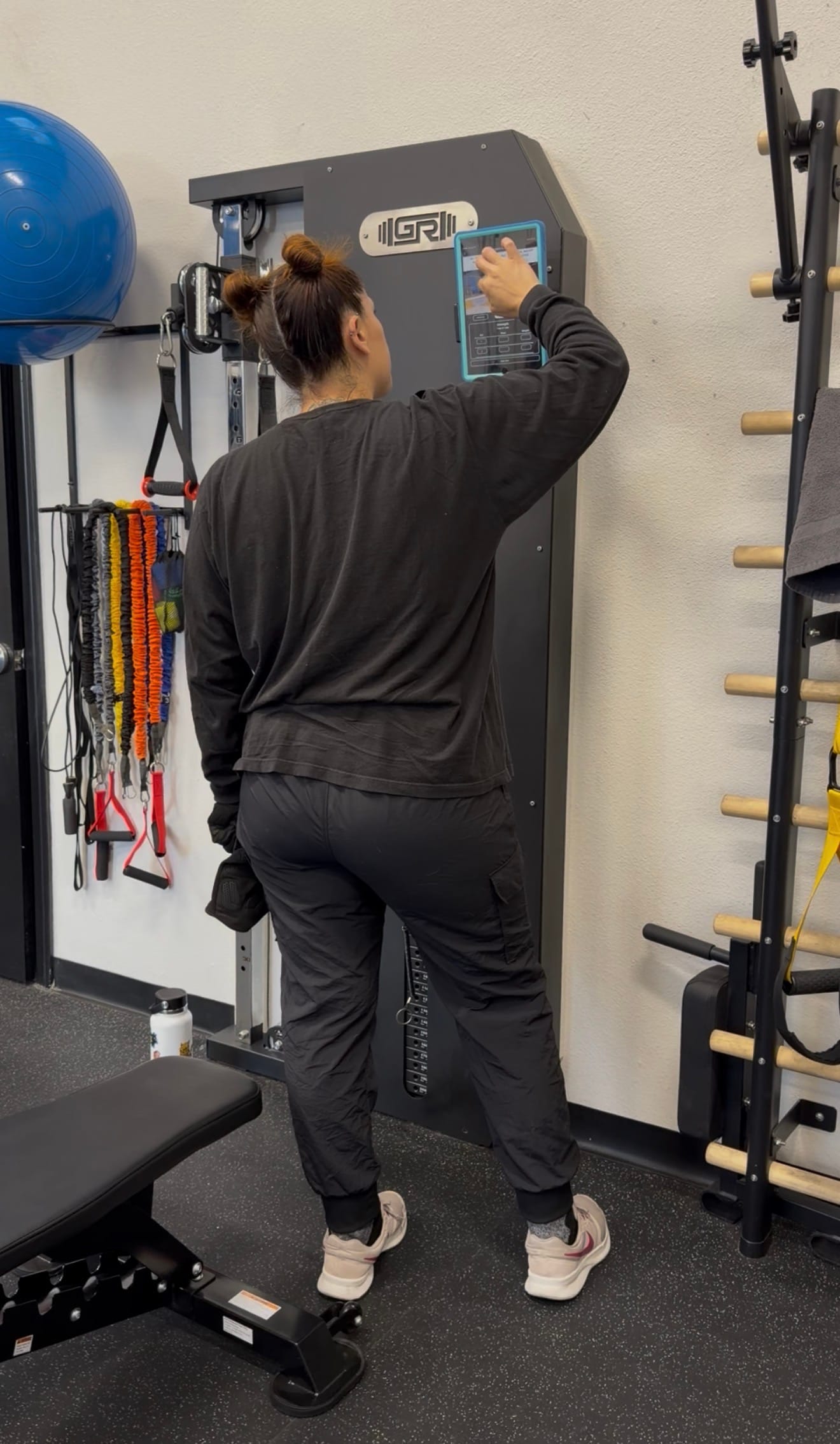 An IMTI member at her training station, opening her program on the station's tablet