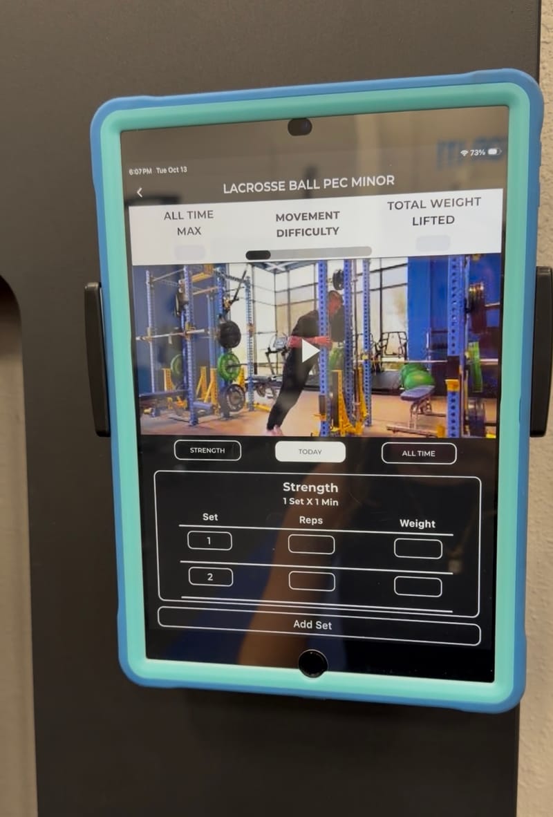 A member's program on the tablet at her training station: today's exercise on video, with her sets, reps and weight to fill in